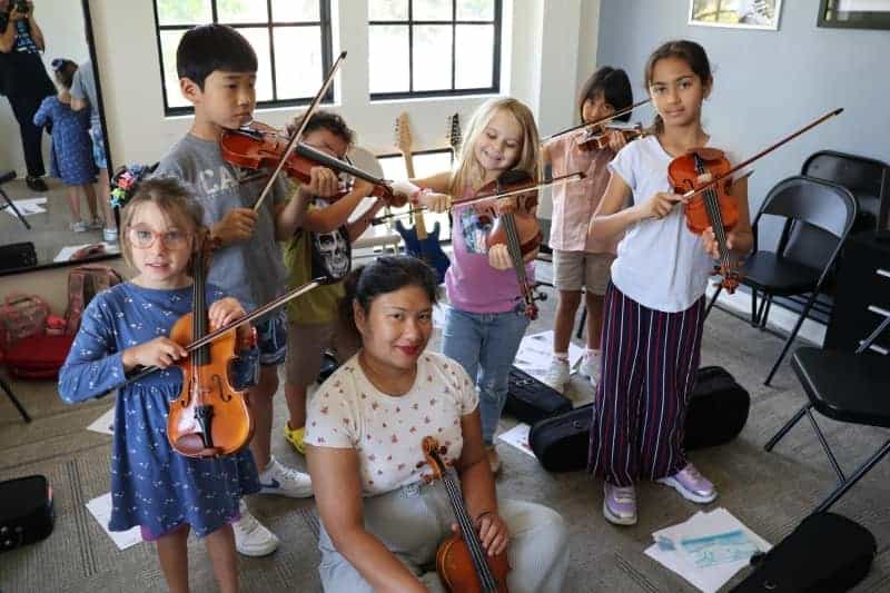 Young students practicing violin at Irvine School of Music summer camp.